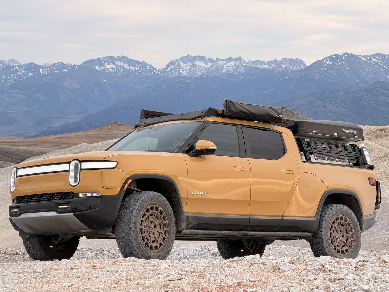 Golden Rivian R1T in the mountains
