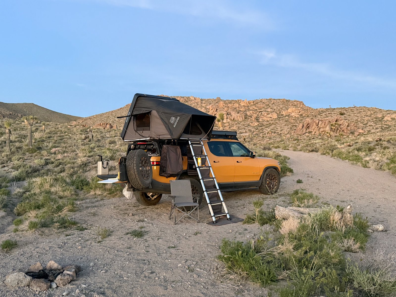 Rivian R1T with rooftop tent open at a desert campsite